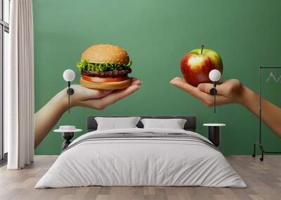 Unhealthy vs healthy food. Burger and apple in different hands on green background . Choice between fast foods and vegetables, fruit.  Wall mural